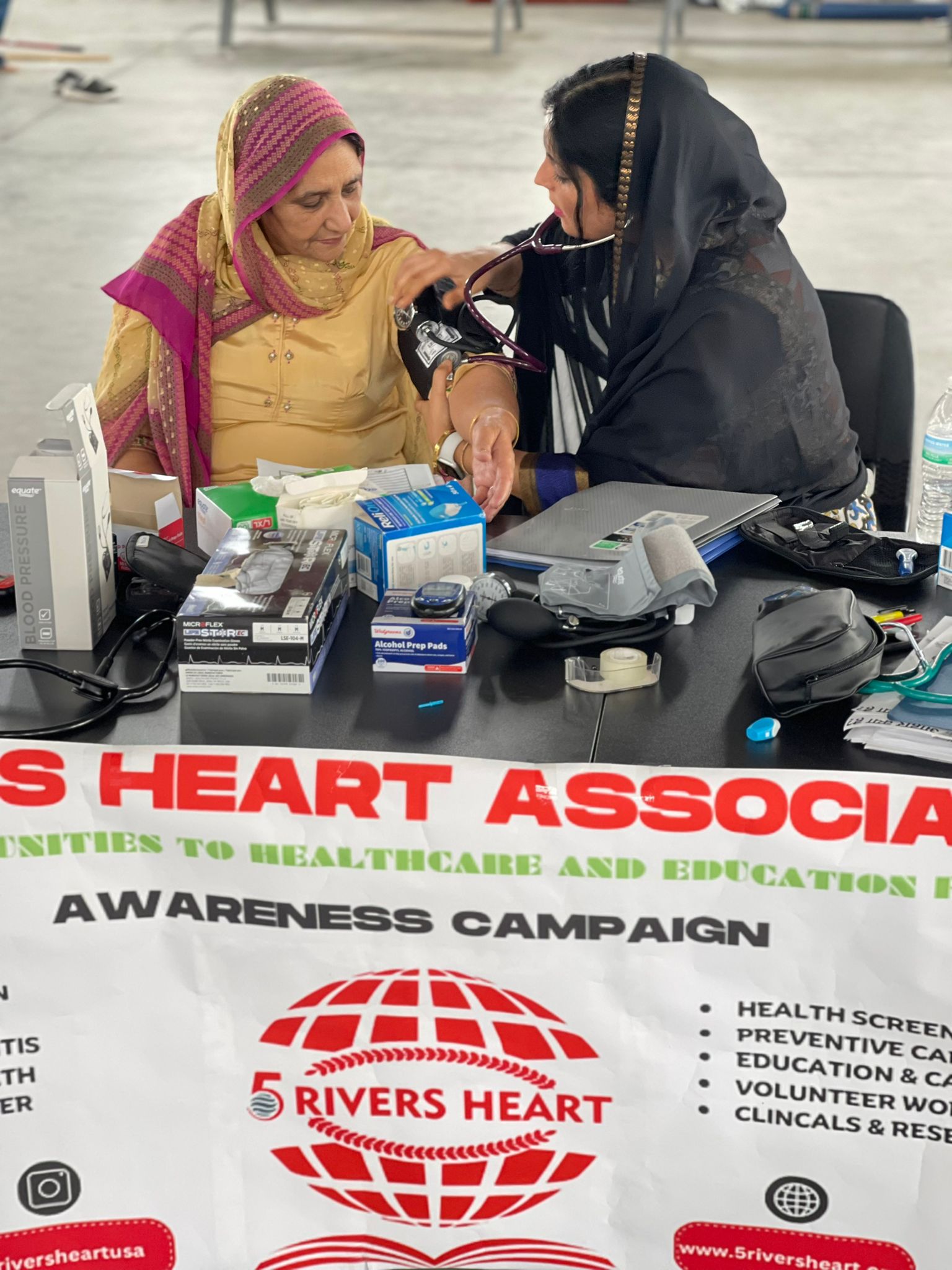 A volunteer checks a community member’s blood pressure at a Houston health camp.